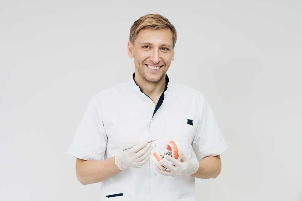 dentist holding fake teeth